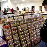 Bill Thinnes looks over the display of Girasol pulp reprints as Girasol’s Leigh Mechem looks for an issue of The Spider.