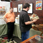 Rich Harvey looks through stacks of Argosy as Tim Cottrell looks on at the Bookery book store in Fairborn, Ohio. Numerous attendees made a pilgrimage to the store for 20% off.
