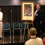 John Goodwin, president of Galaxy Press, donates an autographed lithograph of a Frank Frazetta painting to Pulpcon for auction Saturday night.
